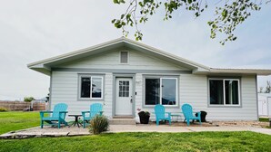 A single-story house with a front porch, a small table, and four turquoise chairs. - Archie's Place: 20 minute's from the Great Sand Dunes (Blanca)
