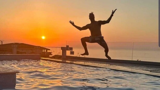 A person jumping into a body of water at sunset. - Tropea, Appartamenti Borgo Panoramico N .10 (Tropea)