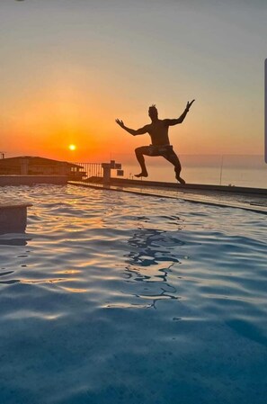 A person jumping into a body of water at sunset. - Tropea, Appartamenti Borgo Panoramico N .10 (Tropea)