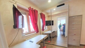 A bedroom with a bed, a desk, a mirror, and a wardrobe. - Tropea, Appartamenti Borgo Panoramico N .10 (Tropea)
