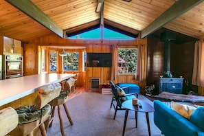 L'intérieur d'un chalet en bois comprend une cuisine, un coin repas et un espace salon.