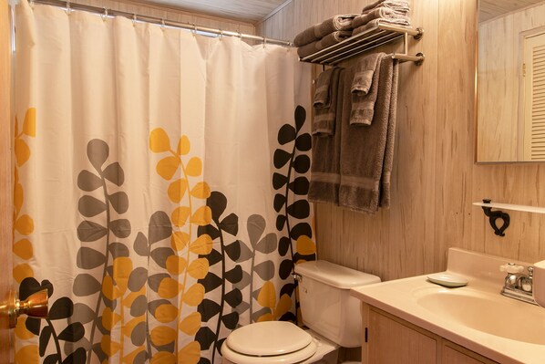 Une salle de bain équipée de toilettes, d’un lavabo et d’un porte-serviettes.