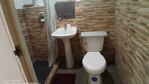 Ein kleines Badezimmer mit Waschbecken, Toilette und Duschvorhang.
