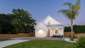 Une maison moderne avec une pelouse bien entretenue, une clôture en bois et un petit jardin.