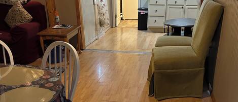 Un comedor con mesa y sillas, un sofá, una cocina al fondo y un ventilador de techo.
