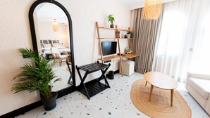 A modern living room with a sofa, a coffee table, a TV, and a bookshelf. - Elysium Garden (Bozyazi)