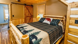 A wooden cabin bedroom with a bed, a ceiling fan, and a window. -  Larsen Lodge Downtown Village Egg Harbor, Sauna, New, Rustic and Elegant. (Egg Harbor)