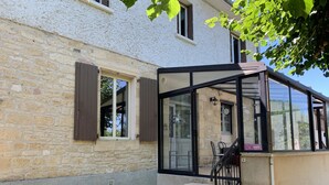 A stone building with a glass entrance and a staircase leading to a covered area. - Listed country house in Périgord between Sarlat, Lascaux and Rocamadour (Salignac-Eyvigues)