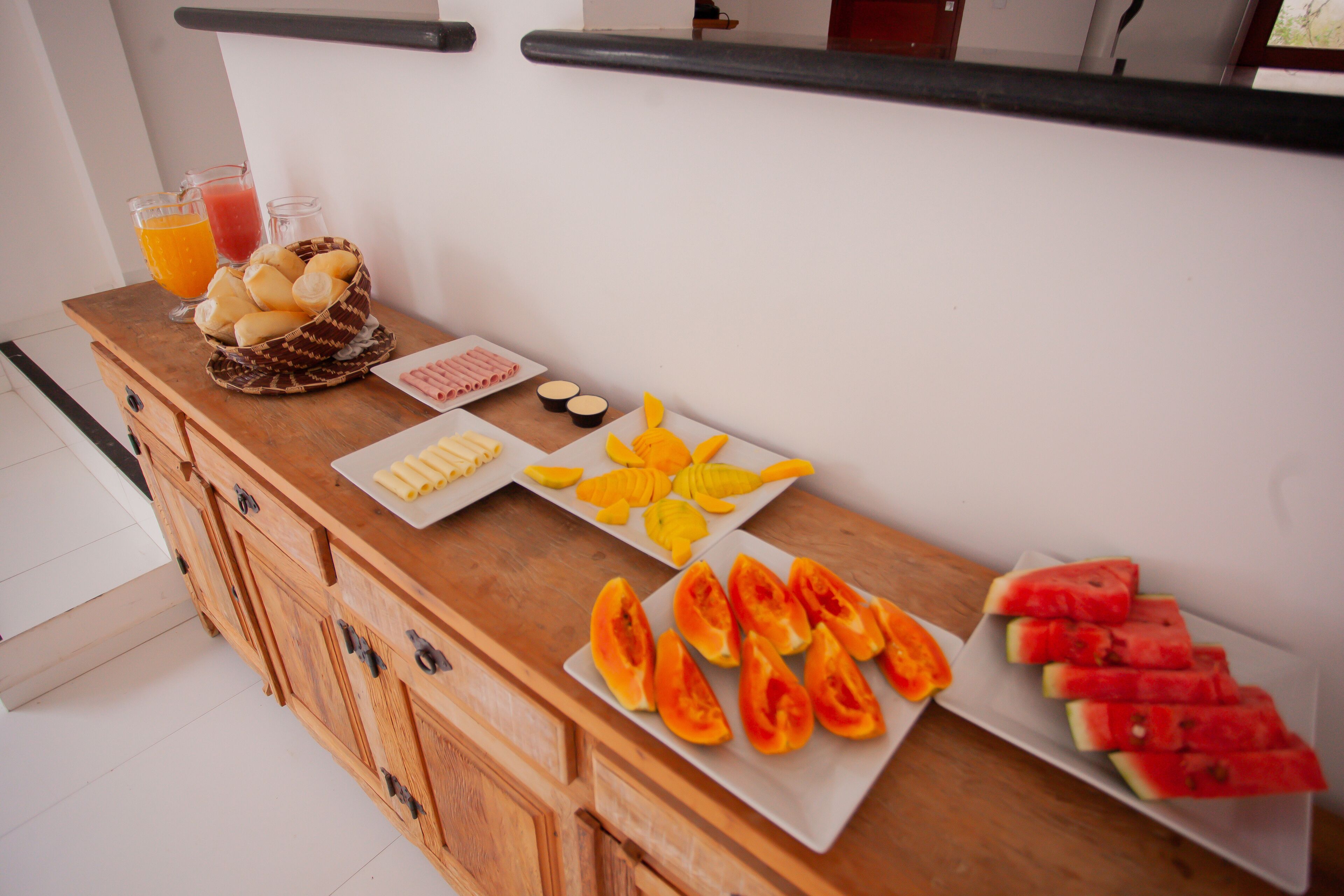 A breakfast buffet with various fruits and beverages.