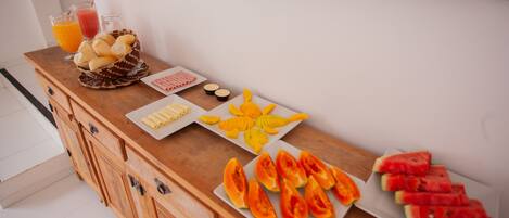 A breakfast buffet with various fruits and beverages.