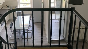 Une cuisine moderne avec un coin repas, un escalier et une vue sur la salle à manger.