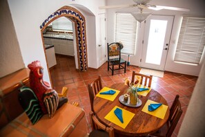 A dining area with a round wooden table, chairs, and a decorative wall archway.