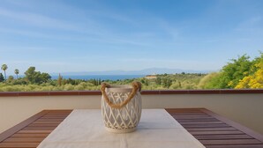 A wooden deck with a table and a woven basket. - Panoramic Villa Sea View  (Quartu Sant'Elena)