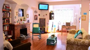 Ein gemütliches Wohnzimmer mit Kamin, Fernseher und Bücherregal.