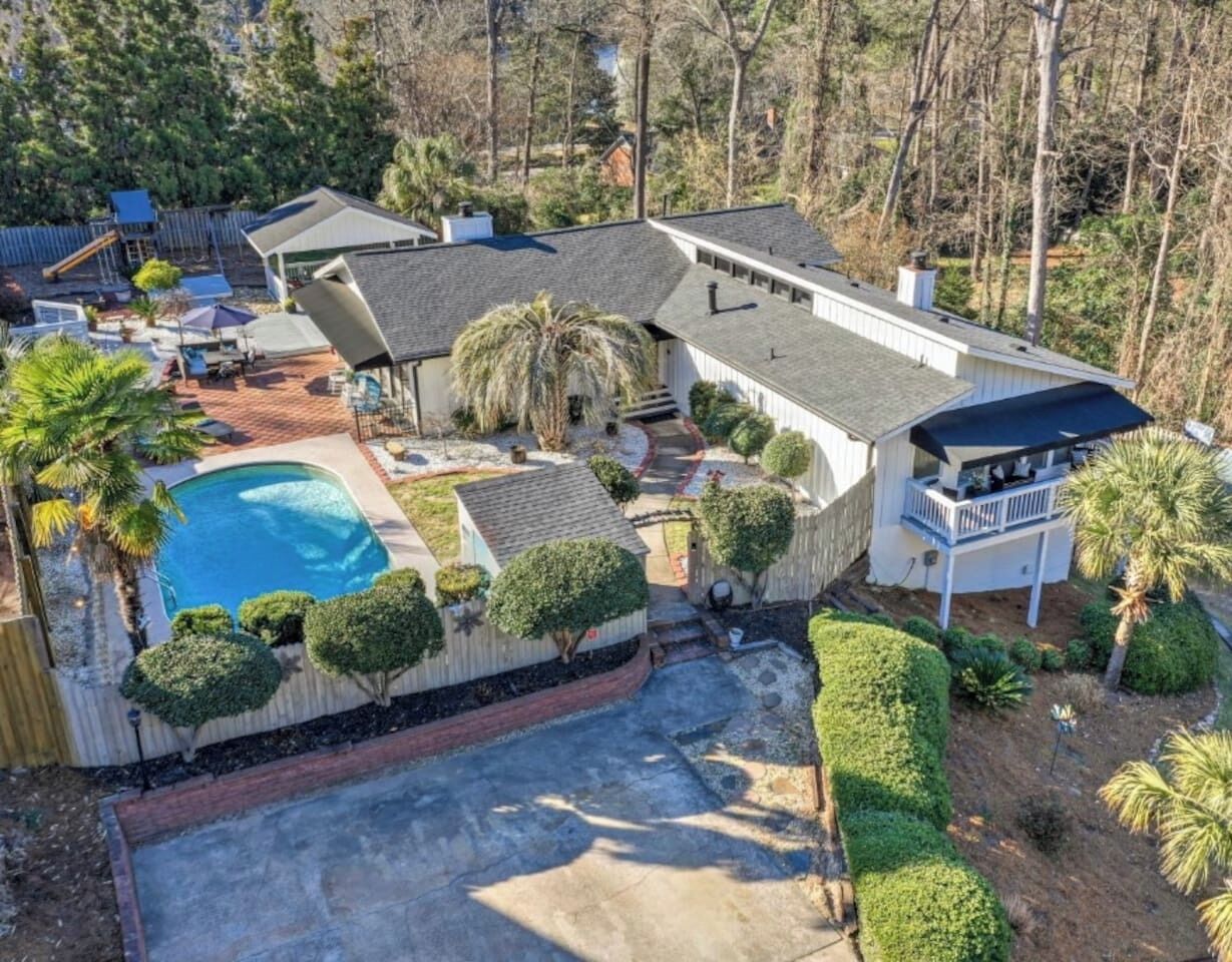 Aerial photo of the rental which includes fun for both kids and adults: a heated pool, Aria Hot tub, and expansive playground.