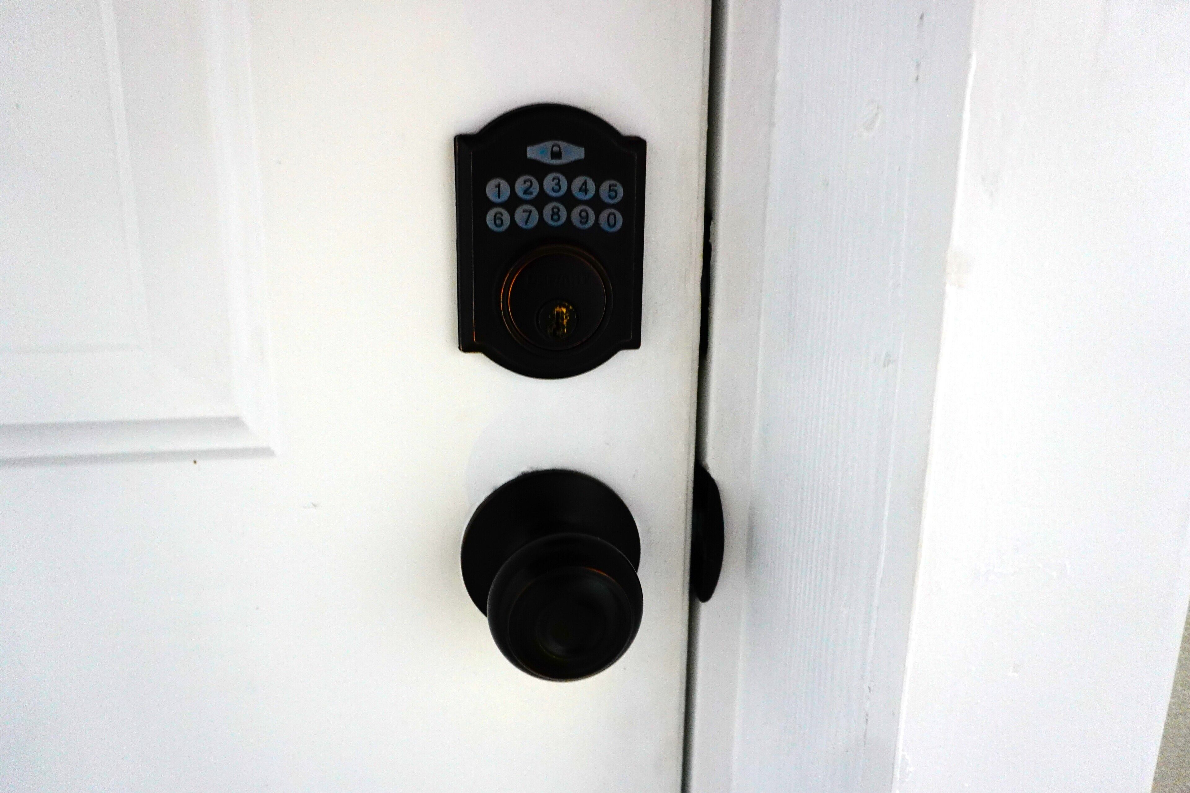 A door with a keypad lock and a peephole.
