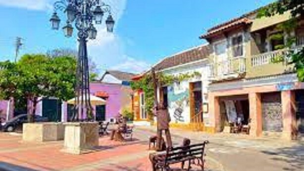 A street scene with a lamp post, benches, and buildings with balconies. - 2CL1-J Apartamento en el Centro Histórico (Cartagena)