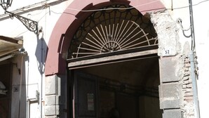 A building entrance with a metal gate and a brick wall.
