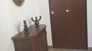 A wooden cabinet with decorative items and a closed door.