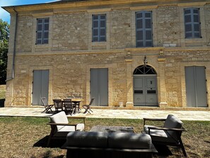 Edificio de piedra con un patio amueblado al aire libre.