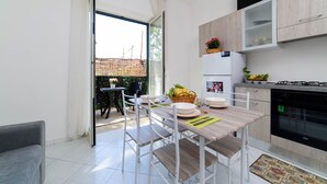 A modern kitchen with a dining area, a sofa, and a view of the outside. - Sottovoce app.to vicino al mare (Piano di Sorrento)