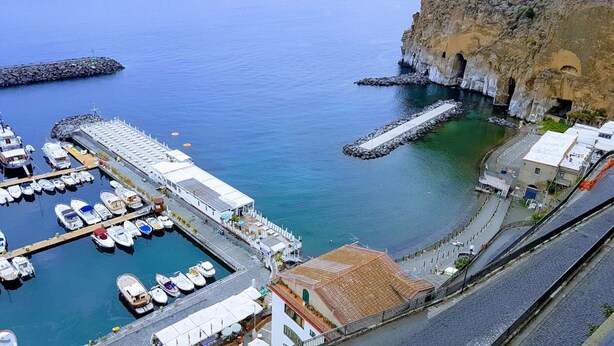 A coastal marina with boats docked, a pier, and buildings along the waterfront. - Sottovoce app.to vicino al mare (Piano di Sorrento)