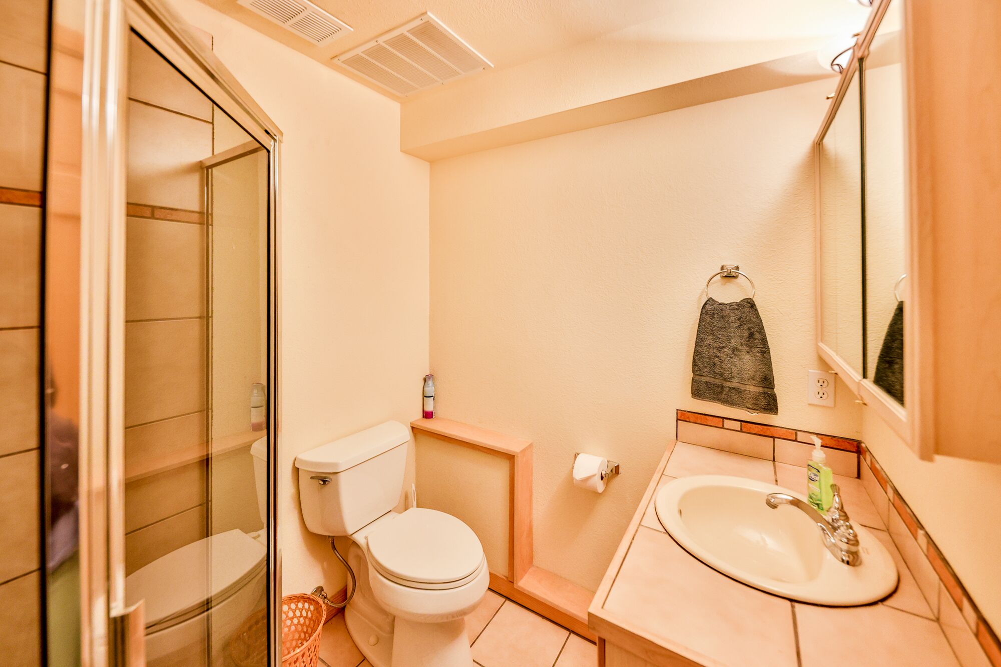 A bathroom with a toilet, sink, and shower.