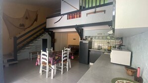 Eine geräumige Küche mit Essbereich, einer Treppe und einem kleinen Kühlschrank.