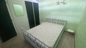 Ein Schlafzimmer mit einem Bett, einem Kleiderschrank und einem kleinen runden Tisch.