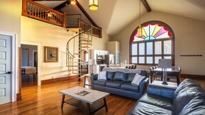 A spacious living room with a staircase, a dining area, and a kitchen. - Dragonfly Inn (Only 40 min to Hocking Hills area) (Amanda)
