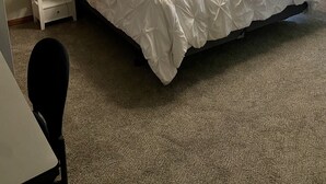 Une chambre à coucher bien aménagée, avec un grand lit, deux tables de chevet avec des lampes, une fenêtre avec des stores et un luminaire au plafond.