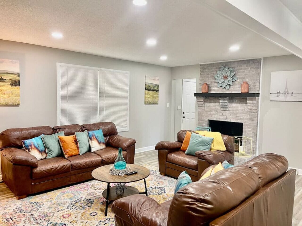 A living room with a brown leather sofa set, a coffee table, and a fireplace.