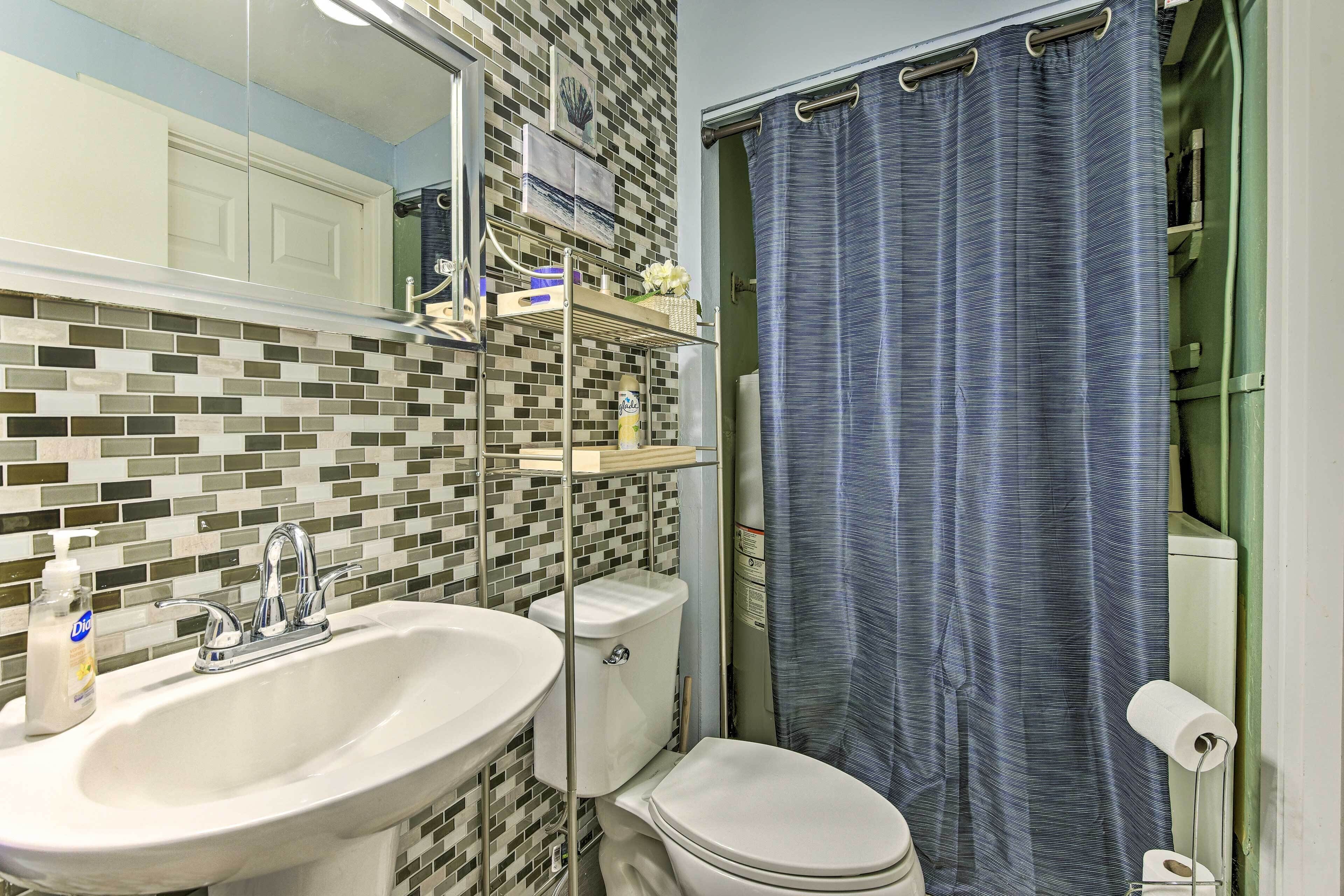 A bathroom with a white sink, a toilet, and a shower curtain.