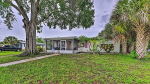 A single-story house with a front porch, a lawn, and a large tree. - North Port Escape w/ Pool ~ 12 Mi to Beach! (North Port)