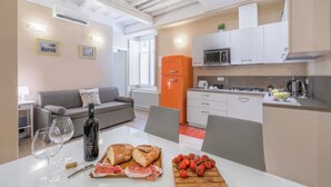 A modern kitchen with white cabinets, a microwave, and a red refrigerator. - Spacious apartment on the first floor, recently renovated, modernly furnished, consisting of two double bedrooms, two complete bathrooms, sofa bed for 2 guests and single bed in the living room. It can comfortably accommodate up to 7 people. WLAN, air con (Firenze)