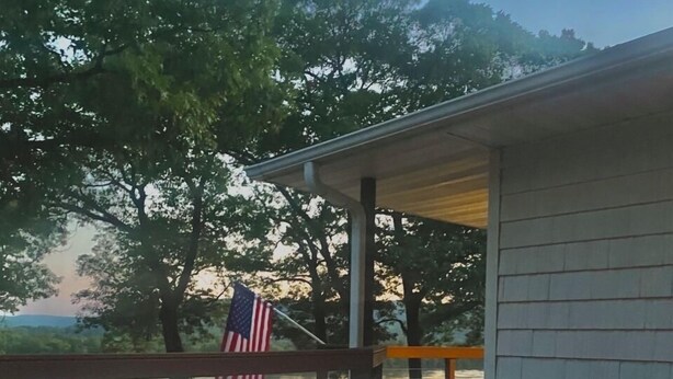 A patio with a fire feature, outdoor seating, and an American flag.