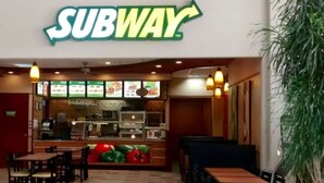 Een Subway restaurant met een balie, menuborden en een zitgedeelte.