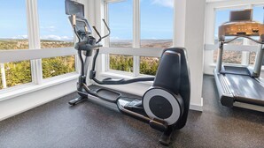 A gym with a treadmill, elliptical, and stationary bike, large windows with a scenic view. - Mountain Lodge - Ski In/Out - 2 Queen Bedrooms + 2 Bunk Beds - Closest To Lifts (Snowshoe)
