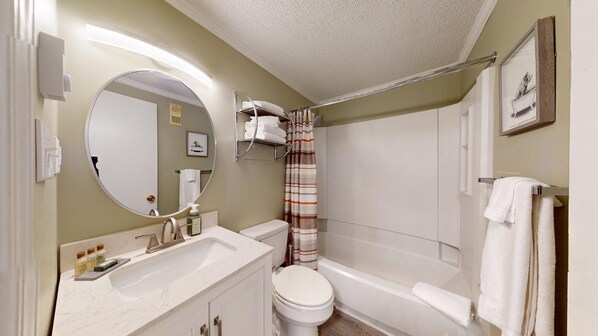 A bathroom with a toilet, sink, and bathtub.