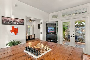 Een woonkamer met een schaakbord, een televisie en een open haard.