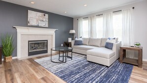 A living room with a fireplace, a sofa, a coffee table, and a lamp. - Westfield Gem! 7 Mins to Grand Park + Movie Room! (Westfield)