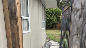 A pathway leading to a house with a wooden fence and a garden. - Chic Private Studio Close to Airport, Bus & Shops - Breakfast included (Christchurch)
