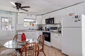 Enjoy meals at the glass-top dining table surrounded by wicker chairs.