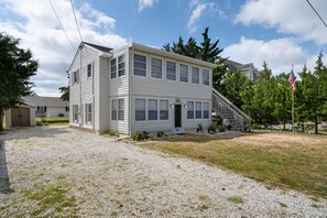 Stunning two-story home with a central entrance, flanked by windows on both levels, and a charming covered porch.