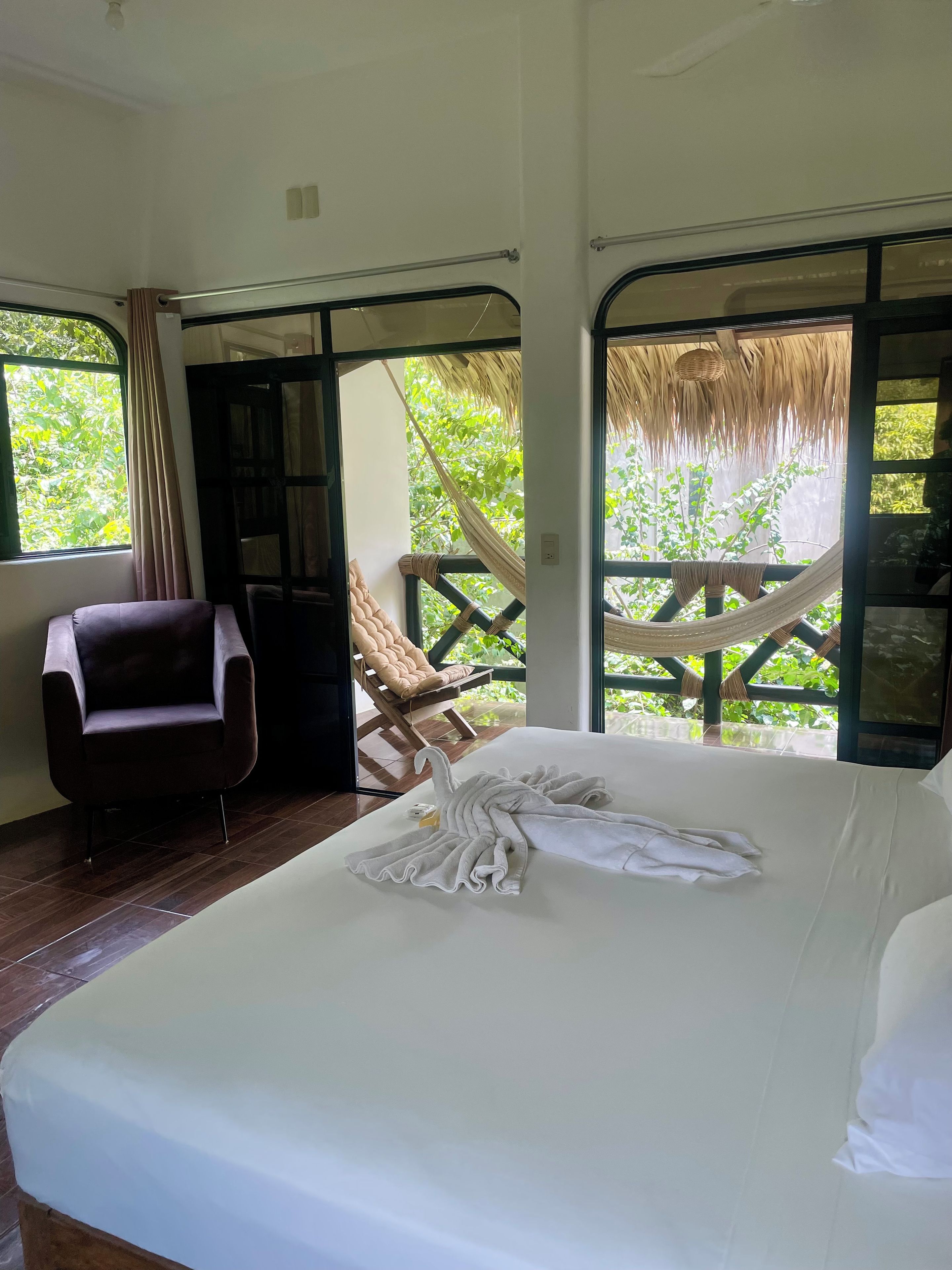 A room with a bed, a chair, and a hammock.