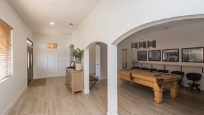 A spacious living area with a pool table, wooden cabinets, and a dining table. - Heated Pool ~ Sleeps 20 ~ HUGE Family Resort Oasis (Lake Havasu City)