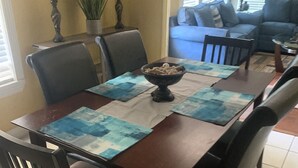 Un coin repas avec une table en bois, des chaises et un bol de nourriture.