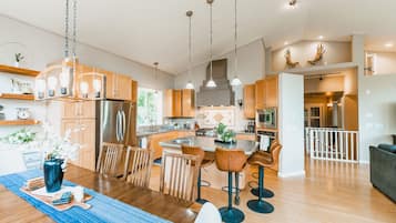 Une cuisine spacieuse avec des meubles en bois, un îlot central et des luminaires suspendus.