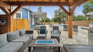 A covered outdoor patio with a pool, seating area, and barbecue grill. - Adorable Laguna Beach Cottage with Pool, 1-Minute Walk to the Beach (Panama City Beach)