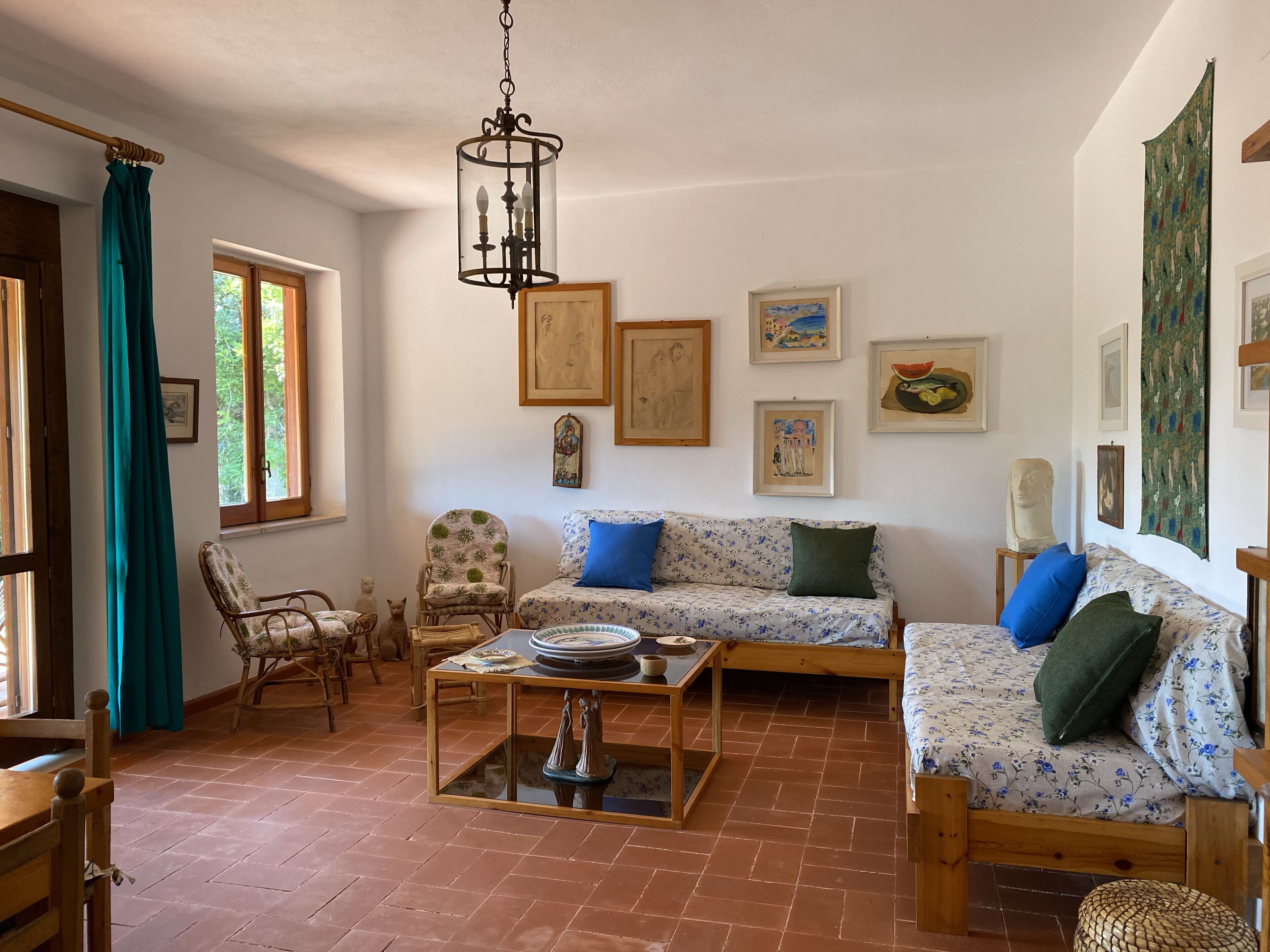 A cozy living room with a sofa, chairs, a coffee table, and artwork on the walls.